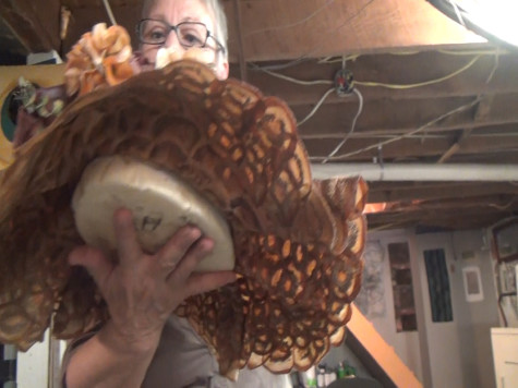 Cudmore holds a hat she made from vegetables in her  studio 
