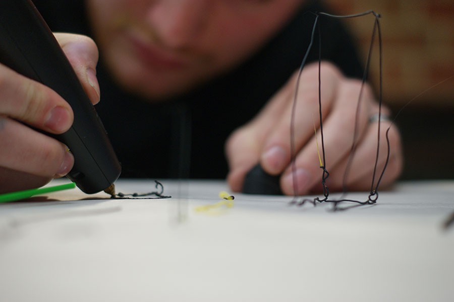 Nash+Laney%2C+fine+arts+student%2C+creates+art+with+a+3Doodler%2C+a+3-D+printer+pen+that+can+be+used+to+design+projects+and+build+creative+ideas+in+the+medium+of+3-D+printing..+Laney+created+a+rectangular+prism%2C+vertical+lines+standing+up+from+the+table+and+3-D+words.%0A