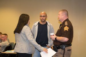 Jennifer Ortiz, visiting assistant professor of criminology, and her husband talk to Clark County Sheriff Jamey Noel prior to him addressing the students. 