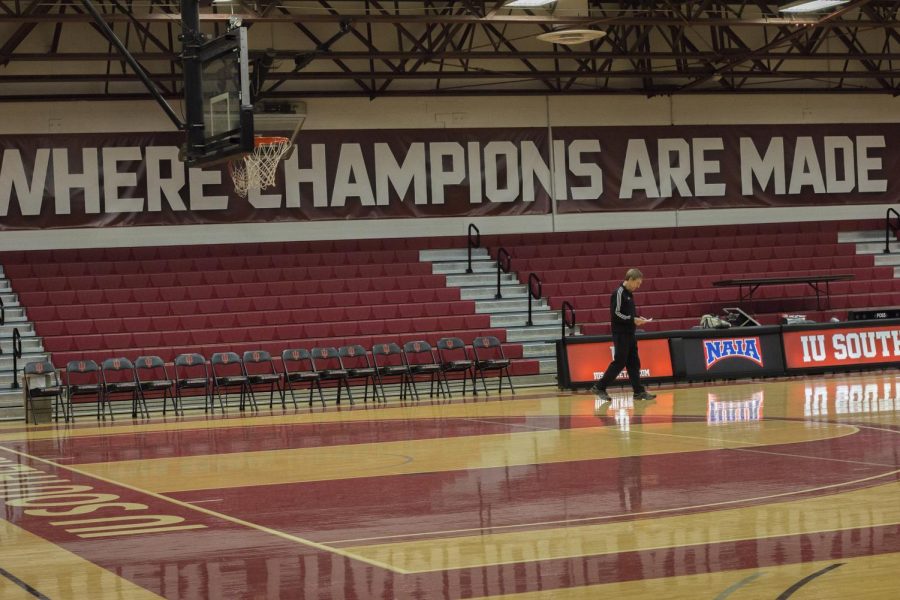 Coach+Robin+Farris%2C+the+newest+member+of+the+NAIA+Division+II+500+win+club%2C+reviews+his+notes+for+practice+before+the+Grenadiers+take+the+floor