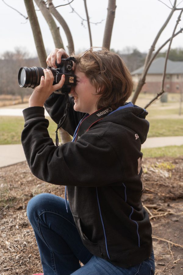Junior Paris Brock looks through the viewfinder on her camera to line up a shot. During class, students are encouraged to experiment with their cameras.