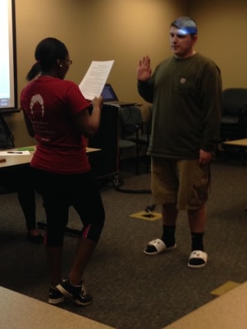 Angel Russel, sociology junior and SGA chief justice, swears in Caleb Bell, secondary social studies education and political science sophomore, during the SGA meeting on Thursday, March 12. Bell is the newest senator in the SGA