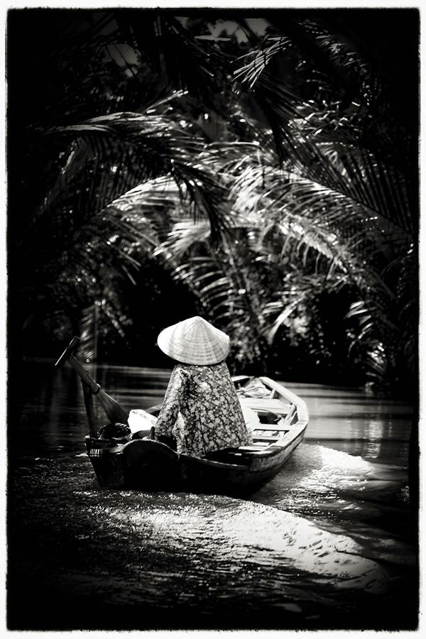 %E2%80%9CI+visited+many+of+these+countries+in+order+to+recruit+students+and+I+had+a+day+off.+I+was+in+Saigon%2C+Ho+Chi+Minh%2C+and+I+was+able+to+hitch+a+ride+to+the+Mekong+Delta%2C+about+an+hour+and+a+half+south.+Then+I+got+on+a+series+of+boats+because+I+wanted+to+go+as+far+into+that+jungle+as+I+could.+I+first+boat+I+was+on+was+big+and+could+hold+about+20+people%2C%E2%80%9D+Wallace+said.%0A%22As+the+river+got+smaller%2C+so+did+the+boats.+Until+he+was+a+boat+big+enough+for+only+him+and+the+driver.+%0A%E2%80%9CShe+passed+us+%28the+woman+in+the+photo%29%2C+and+I+just+loved+that+arch+and+the+light+around+the+boat.%E2%80%9D