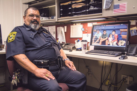 Officer Ruben sits at his desk in his office on campus.