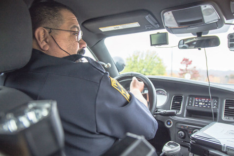 Officer Ruben checks for traffic before merging into  the street to check for parking passes on campus.