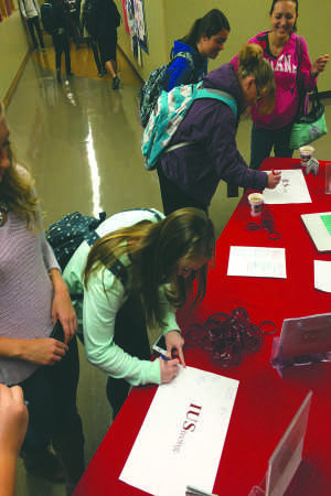 Students make a pledge against sexual violence by signing their names and what made them “IUStrong” on Wednesday, Nov. 11 as part of the It’s On Us campaign.