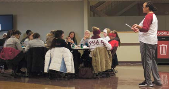 As students students eat pizza, Channell Barbour thanks them for their involvement with the community outreach.