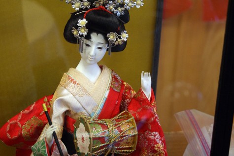 A glass cased statue of a Geshi, the name of a performer of traditional Japanese theater, on display.