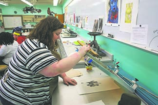 Kacey Slone, printmaking and graphic arts senior, looking at the process of her print.
