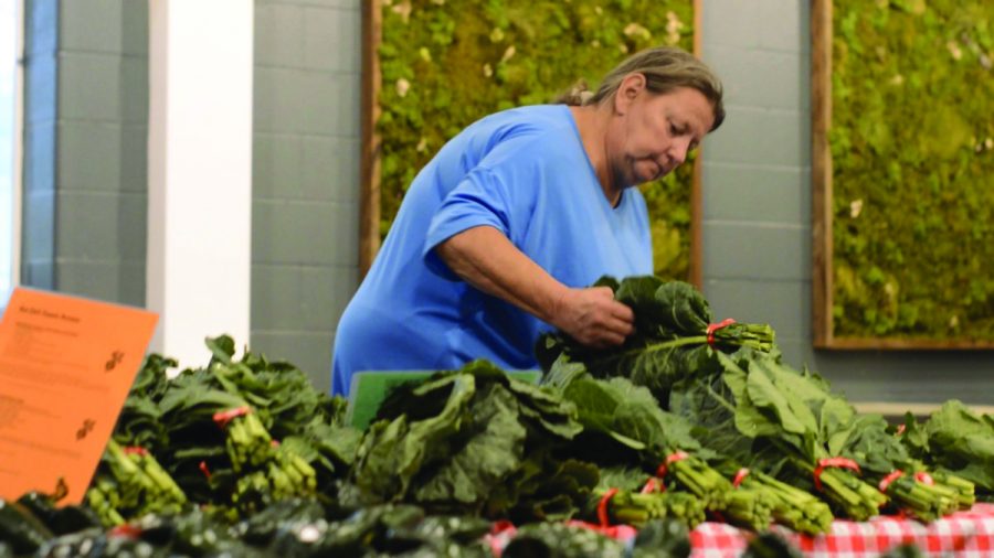 Anita+Rodriguez+picks+out+a+bundle+of+produce+to+add+to+her+bag.+Rodriguez+is+a+New+Albany+resident+and+regular+patron+of+Fresh+Stop+Market.