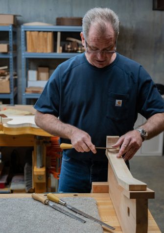 Mabe uses a file to shape an unfinished guitar neck. He hand shapes every piece of every guitar he makes. 